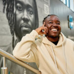 Melz in front of the co-op mural of them