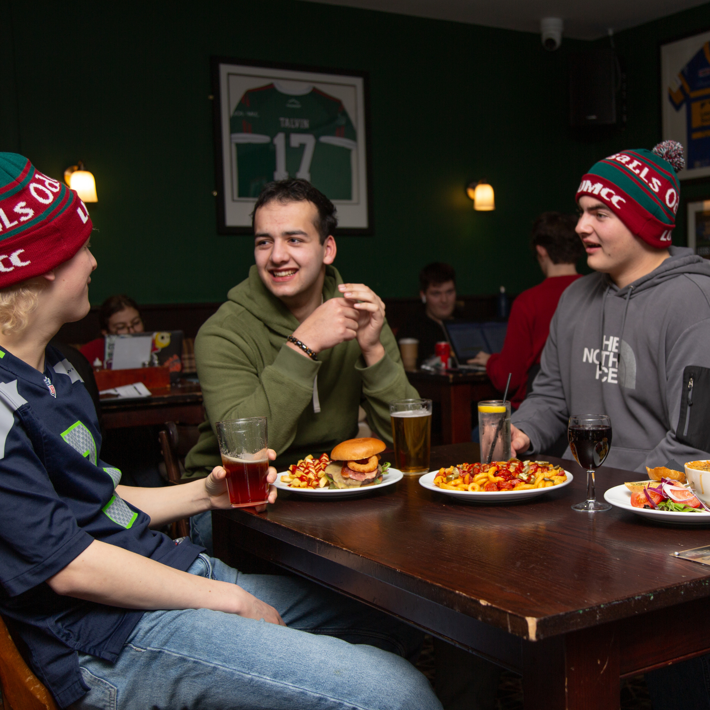 Image of a group of people chatting, with food and drinks from Old Bar.