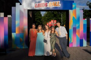 Friends posing under the colourful Leeds Ball arch