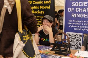 Student laughing at a society stall at the societies fair